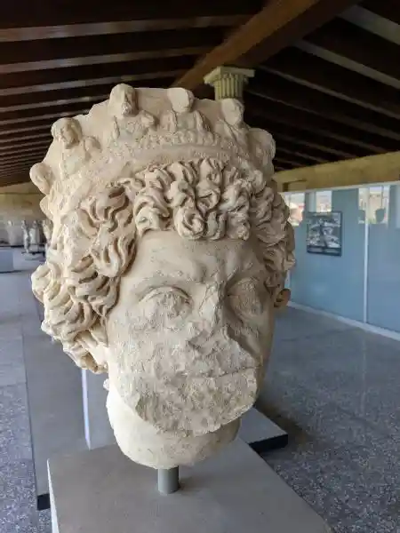 Roman period marble portrait head of a priest crowned with sacred laurel wreath